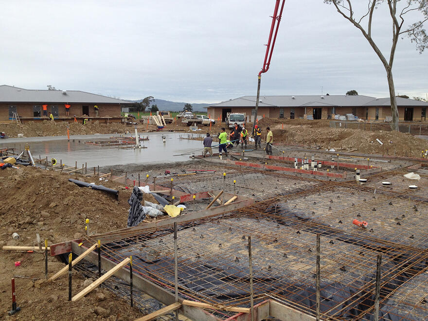 Concrete pouring in progress for a residential slab foundation A crane pouring concrete for a slab foundation